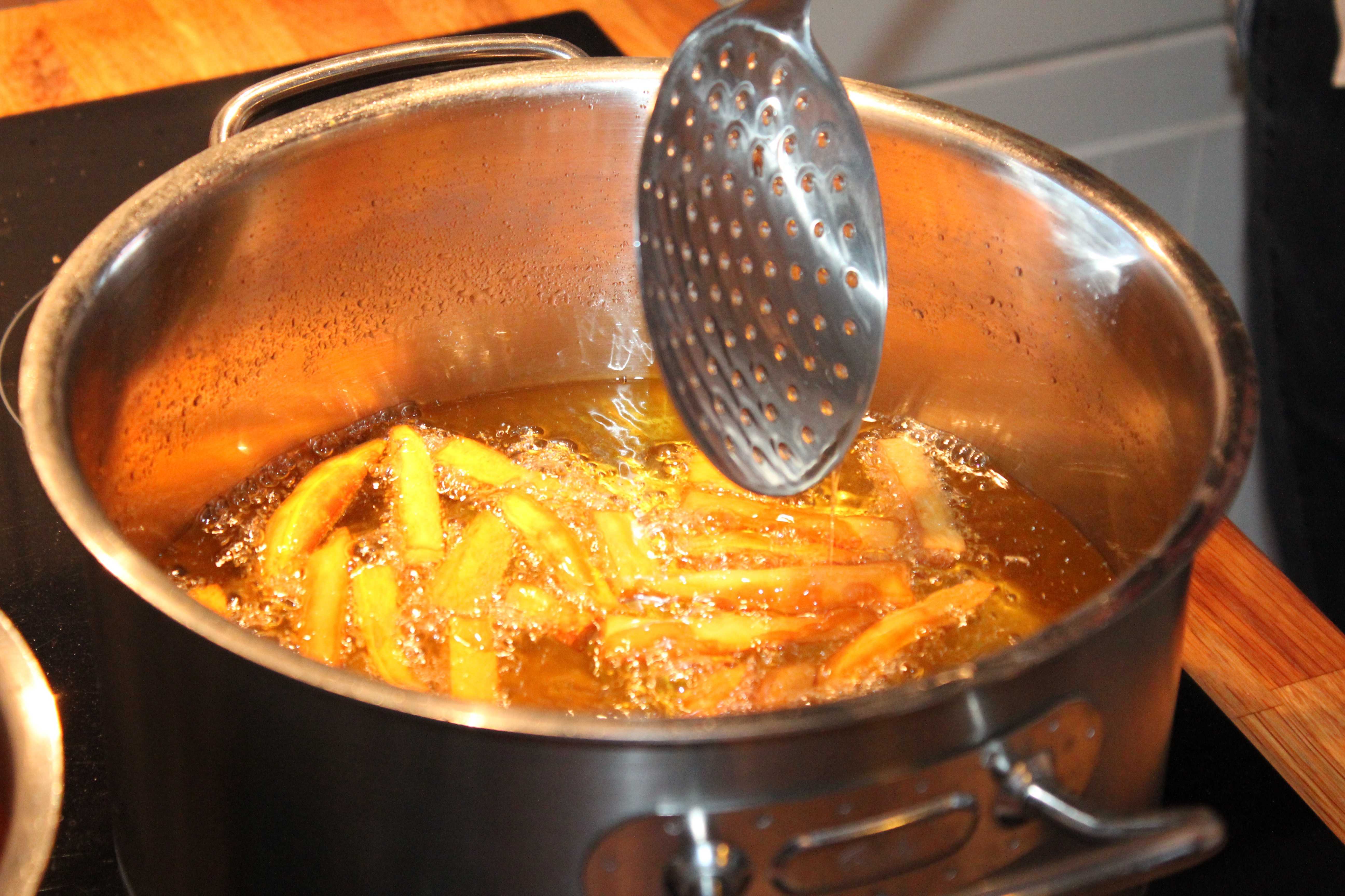 Топленое кипящее масло для приготовления пищи. Картофель во фритюре. Жаренье во фритюре.